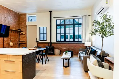 a living room with a couch and a table at Modern industrial suite in Grand Forks in Grand Forks