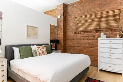 a bedroom with a bed and a brick wall at Modern industrial suite in Grand Forks in Grand Forks