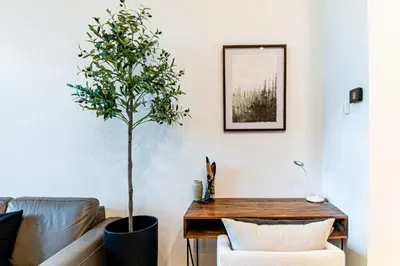 a living room with a table and a potted tree at Modern industrial suite in Grand Forks in Grand Forks