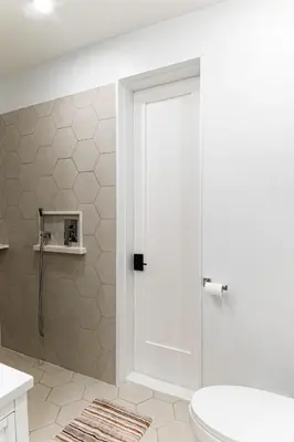 a bathroom with a toilet and a glass shower door at Modern industrial suite in Grand Forks in Grand Forks