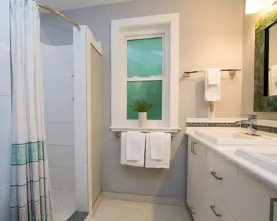 a bathroom with a sink and a shower and a window at Christina Lake Lakefront, Hot Tub, Amazing Views in Christina Lake