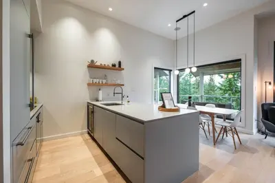 a kitchen with white walls and a dining room with a table at Blueberry Hill Estates 3144 by Outpost Whistler in Whistler
