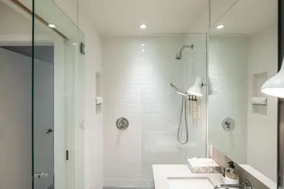 a white bathroom with a shower and a sink at Blueberry Hill Estates 3144 by Outpost Whistler in Whistler