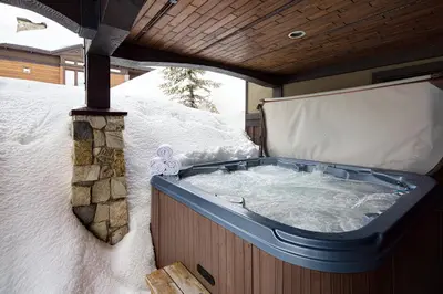 a jacuzzi tub in the back of a snow covered at Dwight Out Chalet with Hot Tub in Big White
