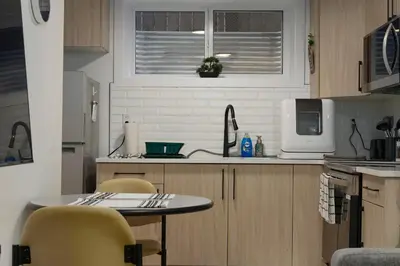 a kitchen with a table and chairs and a microwave at Modern Suite by Royal Alexandra Hospital l Free Parking WiFi Netflix in Edmonton