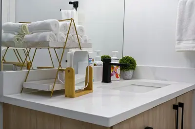 a white kitchen with a counter with a rack of towels at Modern Suite by Royal Alexandra Hospital l Free Parking WiFi Netflix in Edmonton