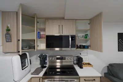 a kitchen with a stove and a microwave at Modern Suite by Royal Alexandra Hospital l Free Parking WiFi Netflix in Edmonton