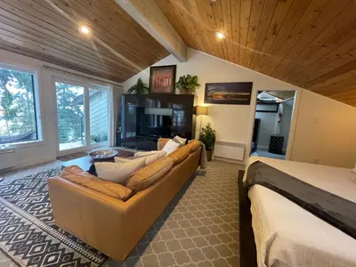a large living room with a couch and a bed at Tyee Beach Oasis Bed and Breakfast in Nanoose Bay
