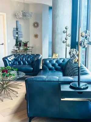 a living room with a blue couch and a table at Urban Oasis - Comfort & Luxury in Calgary