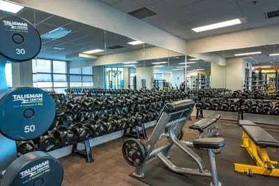 a gym with rows of exercise equipment in it at Urban Oasis - Comfort & Luxury in Calgary