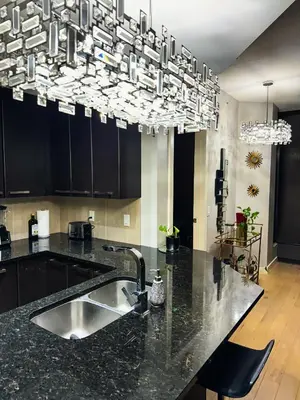 a kitchen with a sink and a chandelier at Urban Oasis - Comfort & Luxury in Calgary