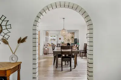 an archway leads into a dining room and living room at Digital Nomad's Calgary Inner City Gem 3Bd, 5Bed, Sleeps 8, Main Level in Calgary