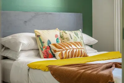 a bed with pillows and a yellow blanket on it at Digital Nomad's Calgary Inner City Gem 3Bd, 5Bed, Sleeps 8, Main Level in Calgary