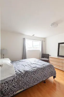 a bedroom with a bed and a television in it at PNE Delight in Vancouver