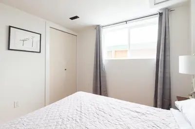 a bedroom with a bed and a window at PNE Delight in Vancouver