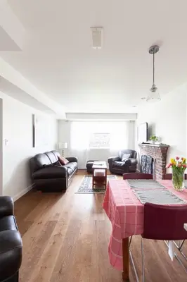 a living room with leather furniture and a fireplace at PNE Delight in Vancouver