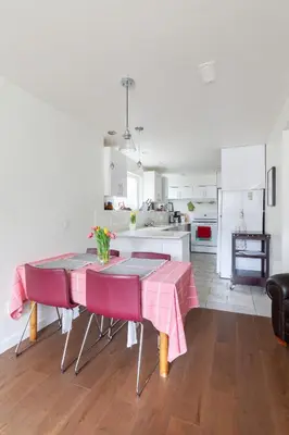 a kitchen with a table with a pink table cloth at PNE Delight in Vancouver
