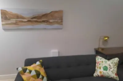 a living room with a couch and a painting on the wall at Carsonway Basement Suite in Edmonton