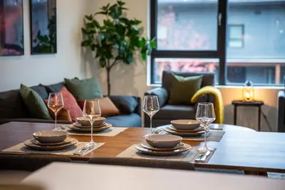a table with plates and wine glasses on it at Cedar and Loam by Revelstoke Vacations in Revelstoke