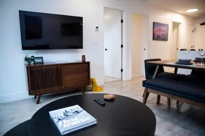 a living room with a table and a tv at Cedar and Loam by Revelstoke Vacations in Revelstoke