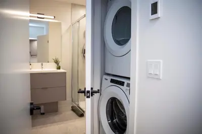 a washing machine in a bathroom with a sink at Cedar and Loam by Revelstoke Vacations in Revelstoke
