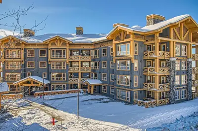 a large building with snow on the ground at Stonegate Resort Unit A205 in Big White