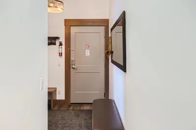 a door leading into a room with a stair case at Stonegate Resort Unit B408 in Big White