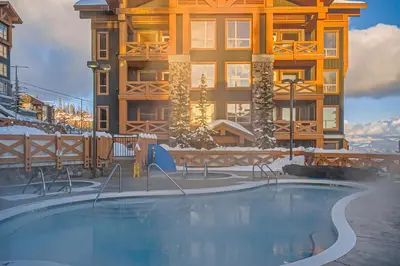 a swimming pool in front of a building in the snow at Stonegate Resort Unit B408 in Big White