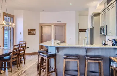 a kitchen with a blue counter and wooden stools at Stonegate Resort Unit B408 in Big White