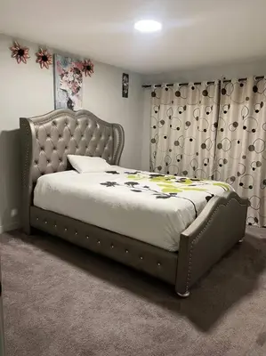 a bedroom with a large bed with a tufted headboard at ZierHomes in Devon