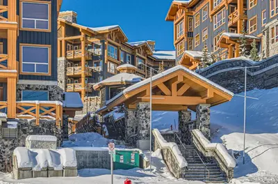 a ski lodge with a staircase in the snow at Stonegate Resort Unit B302 in Big White