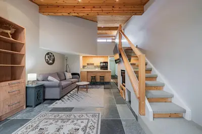 a living room with a staircase and a couch at Shorewater Resort, Qualicum Beach in Qualicum Beach