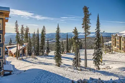 a group of trees in the snow next to a building at Stonegate Resort Unit B103 in Big White