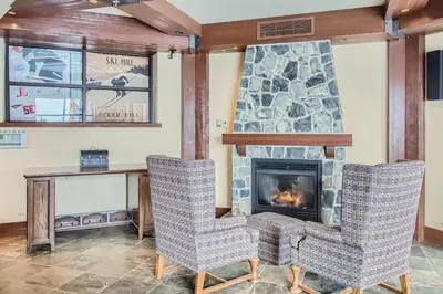 a living room with two chairs and a fireplace at Stonegate Resort Unit B103 in Big White