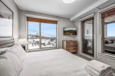 a bedroom with a bed and a large window at Stonegate Resort Unit C106 in Big White