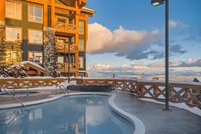 a swimming pool in front of a building at Stonegate Resort Unit C103 in Big White