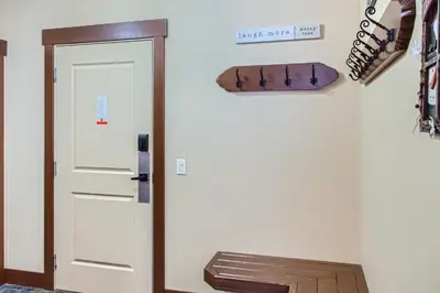a hallway with a door and a bench next to it at Stonegate Resort Unit C103 in Big White