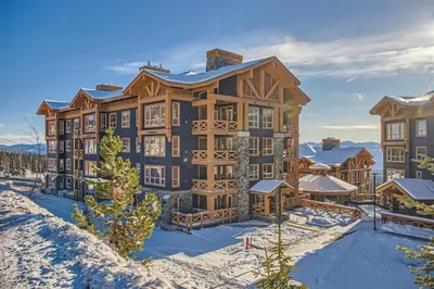 a large building with snow in front of it at Stonegate Resort Unit C103 in Big White