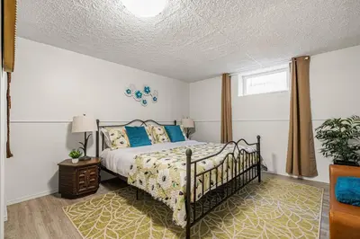a bedroom with a bed with blue pillows at Voyager's Hub- Calgary InnerCity 3BD 4Bed Sleeps 8 in Calgary