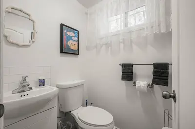 a white bathroom with a toilet and a sink at Voyager's Hub- Calgary InnerCity 3BD 4Bed Sleeps 8 in Calgary