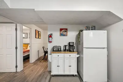a kitchen with a white refrigerator and a bedroom at Voyager's Hub- Calgary InnerCity 3BD 4Bed Sleeps 8 in Calgary