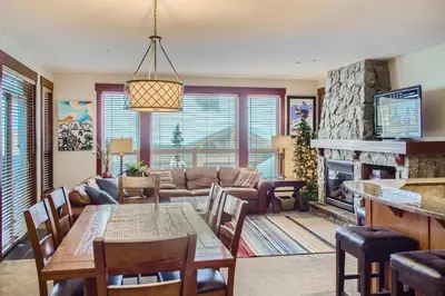 a living room with a table and a fireplace at Stonegate Resort Unit A202 in Big White