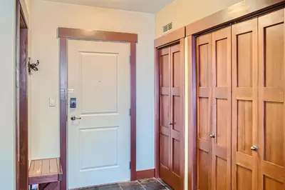 a closet with a white door and wooden cabinets at Stonegate Resort Unit A202 in Big White