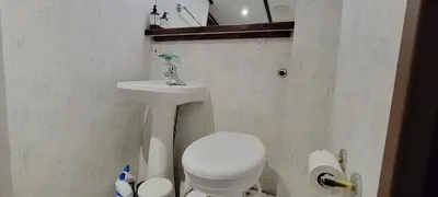 a small bathroom with a toilet and a sink at Shangri-la Cheer in Vancouver