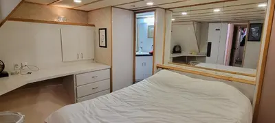 a small bedroom with a bed and a mirror at Shangri-la Cheer in Vancouver