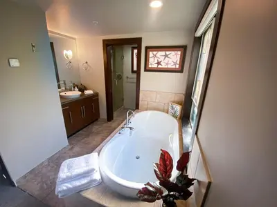 a large bathroom with a tub and a sink at Stylish Family Condo at Beachfront Resort in Parksville