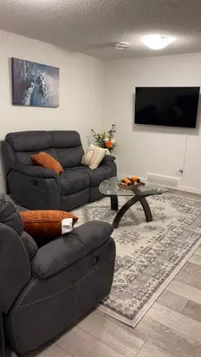 a living room with a couch and a table at Exquisite Basement Suite, 7mins away to Landmark Cinema and Malls in Calgary