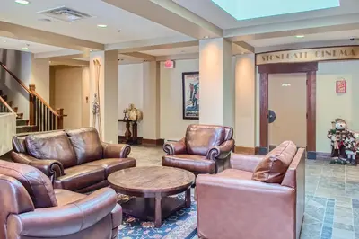 a waiting room with leather chairs and a table at Stonegate Resort Unit B107 in Big White