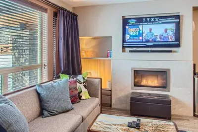 a living room with a couch and a tv at Stonegate Resort Unit B107 in Big White