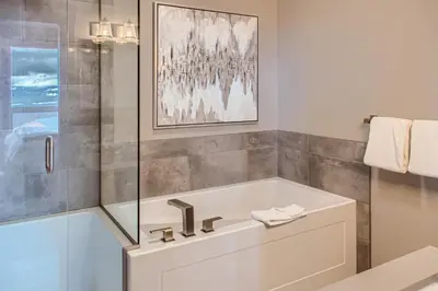 a white bathroom with a tub and a shower at Stonegate Resort Unit B401 in Big White